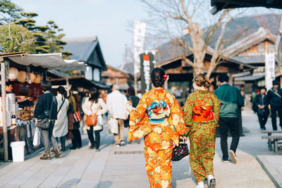 Rear view of woman in kimono walking at market
