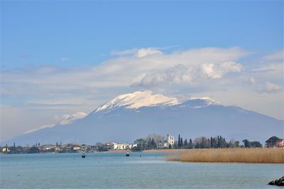 Scenic view of sea by buildings against sky