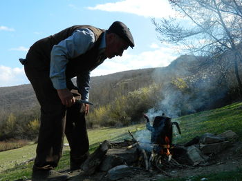 Man making fire on pasture