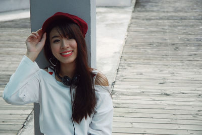 Portrait of smiling woman sitting on footpath in city