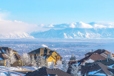 Panoramic view of buildings and mountains against sky during winter