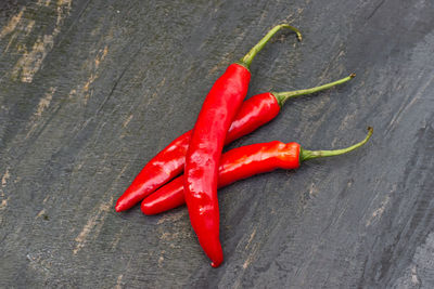 High angle view of red chili peppers on wood