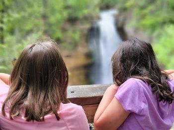 Rear view of girl with mother in water
