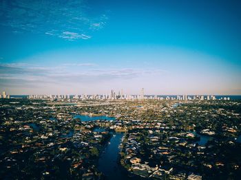 Aerial view of cityscape against blue sky