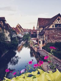 High angle view of buildings by river in town against sky