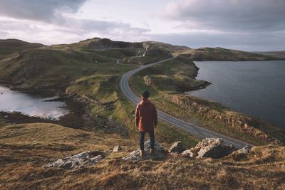 Rear view full length of man standing on mountain against empty road