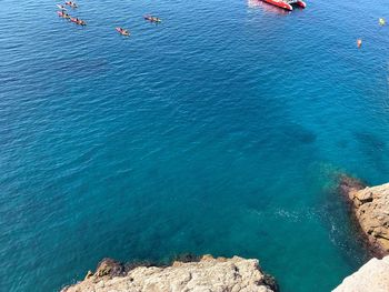 High angle view of people on rocks by sea