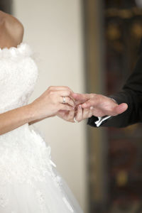 Midsection of bride holding wedding dress