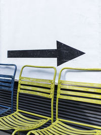 Empty chairs and table against wall
