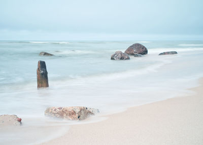 Rocks on beach against sky