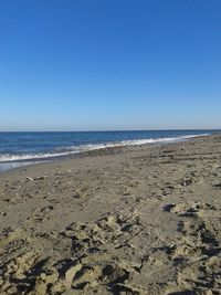 Scenic view of beach against clear blue sky