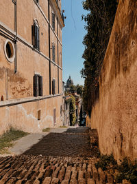 Footpath amidst buildings against sky