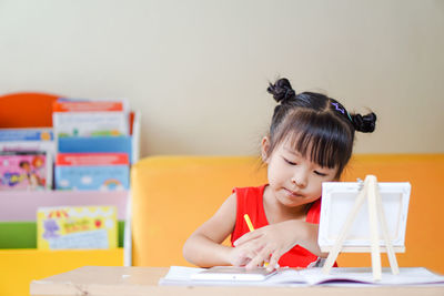 Close-up of cute girl sitting by table