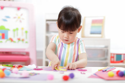 Young girl making paper craft at home