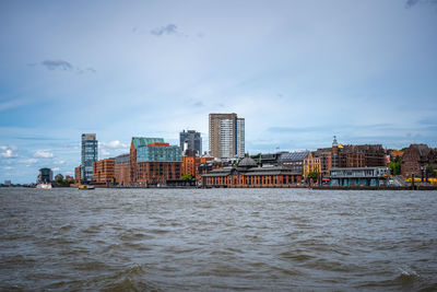 River by buildings against sky in city