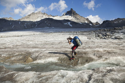 Man takes pictures on snowbird glacier, talkeetna mountains, alaska