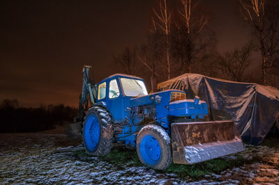 View of abandoned car on field at night