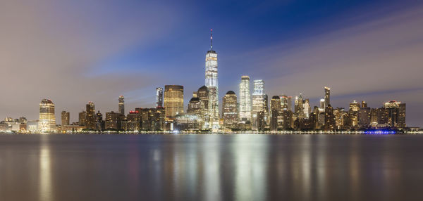 Illuminated buildings in city at waterfront