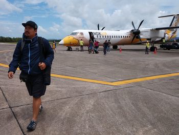 Man with umbrella walking on airport runway