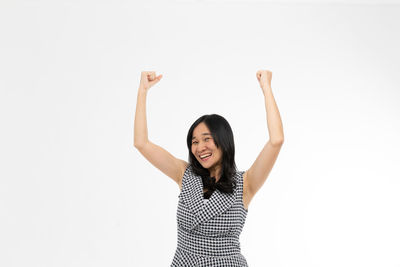 Portrait of smiling young woman against white background