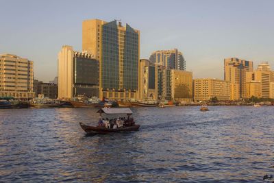 Boat in sea against buildings in city