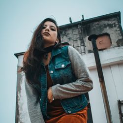 Low angle view of beautiful woman standing against building