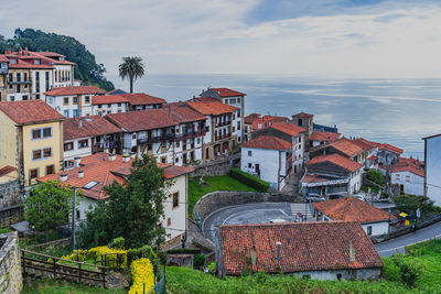 High angle view of townscape by sea against sky
