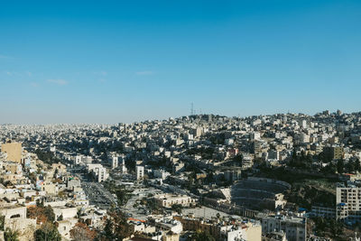 High angle view of illuminated buildings against blue sky