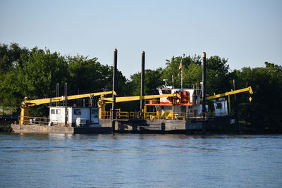 Boats in bayou against clear sky