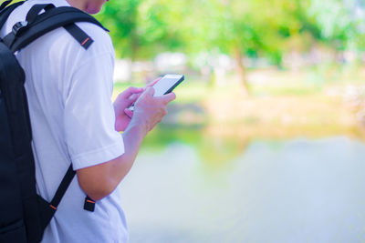 Midsection of man using mobile phone