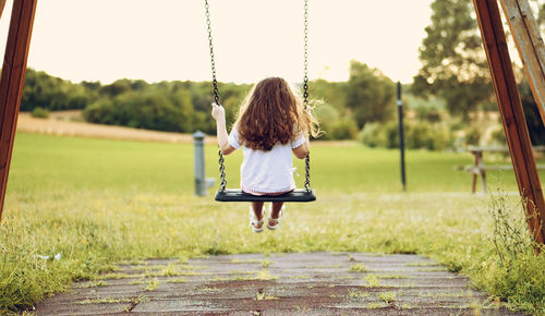 Rear view of woman on swing in playground