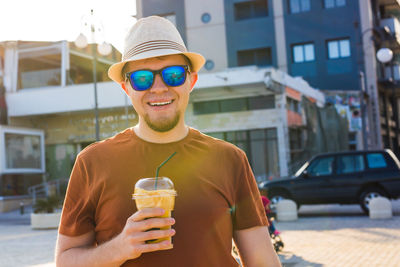 Portrait of a young man drinking glass