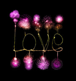 Illuminated firework display over black background