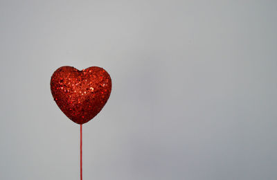 Close-up of red heart shape over white background