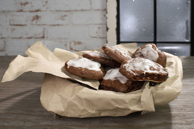 Homemade gingerbread biscuits with almonds and icing lie on wrapping paper.  iced up window.