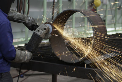 Low angle view of man working on metal in factory