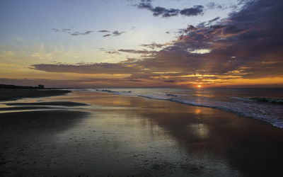 Scenic view of beach against sky during sunset