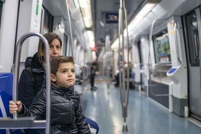 Mother and son sitting in train