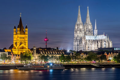 Yacht sailing in rhine river against illuminated cologne cathedral