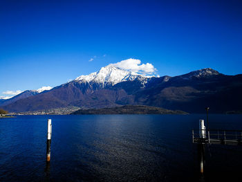 Scenic view of lake and mountains against blue sky