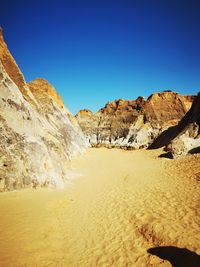 Scenic view of desert against clear blue sky