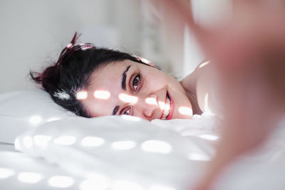 Portrait of woman lying on bed