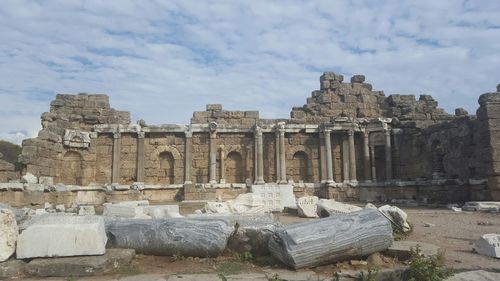 Low angle view of old ruin against cloudy sky