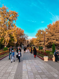 People walking on footpath during autumn