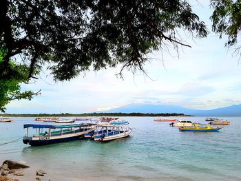 Boats moored in sea against sky