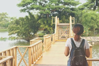 Rear view of woman standing on footbridge