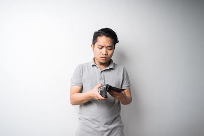 Man looking away while standing against white background