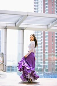 Portrait of young woman dancing in city