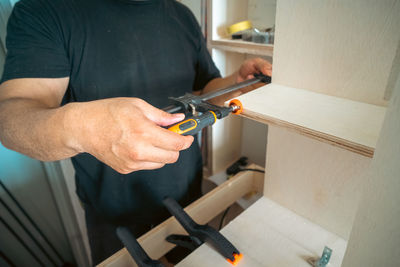 Clamps holding workpiece gluing by the carpenter, close-up