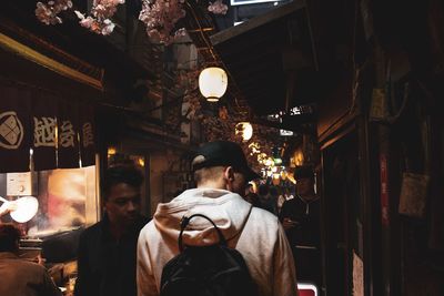 Rear view of man at illuminated market